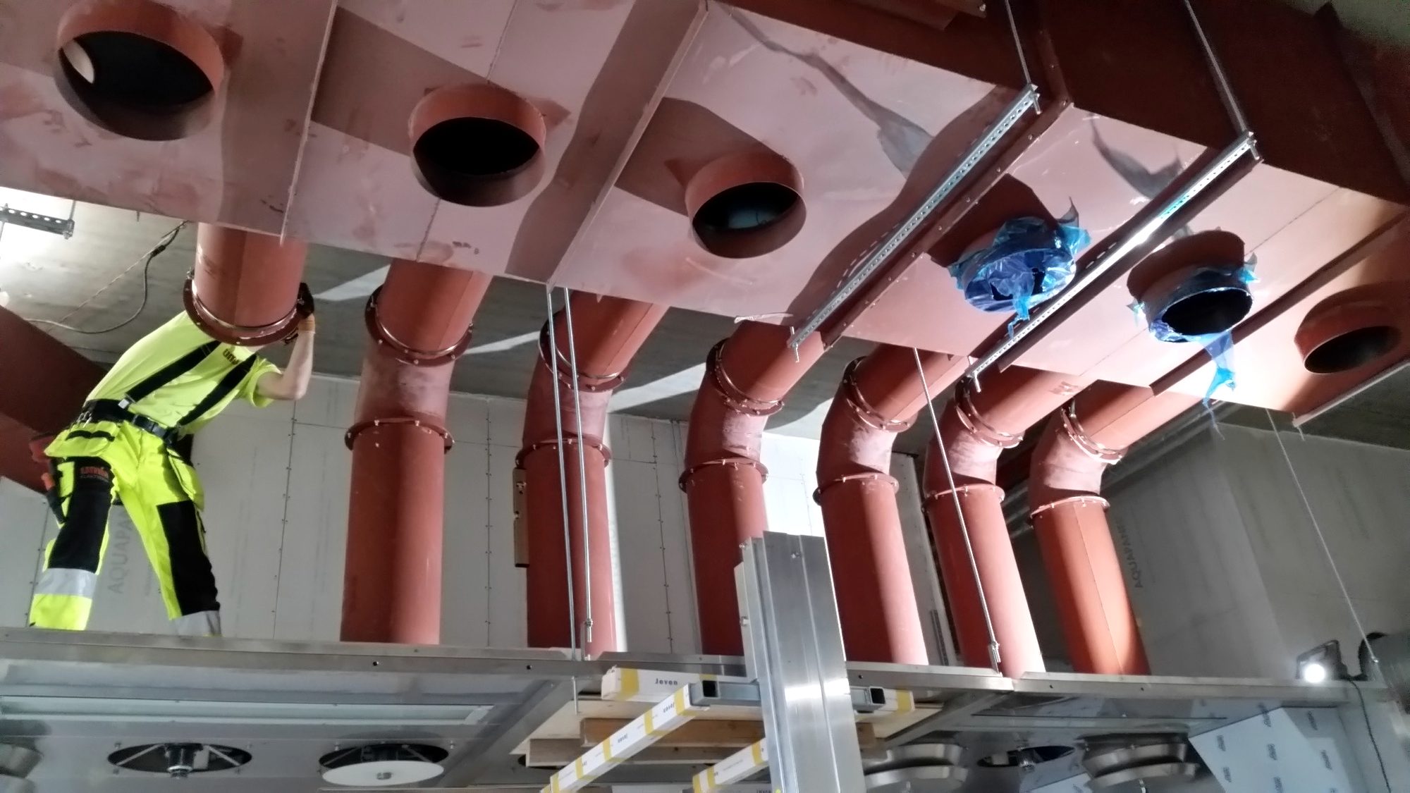 Montör installerar ventilationskanaler i tak under pågående projekt — KDM Ventilation Stockholm