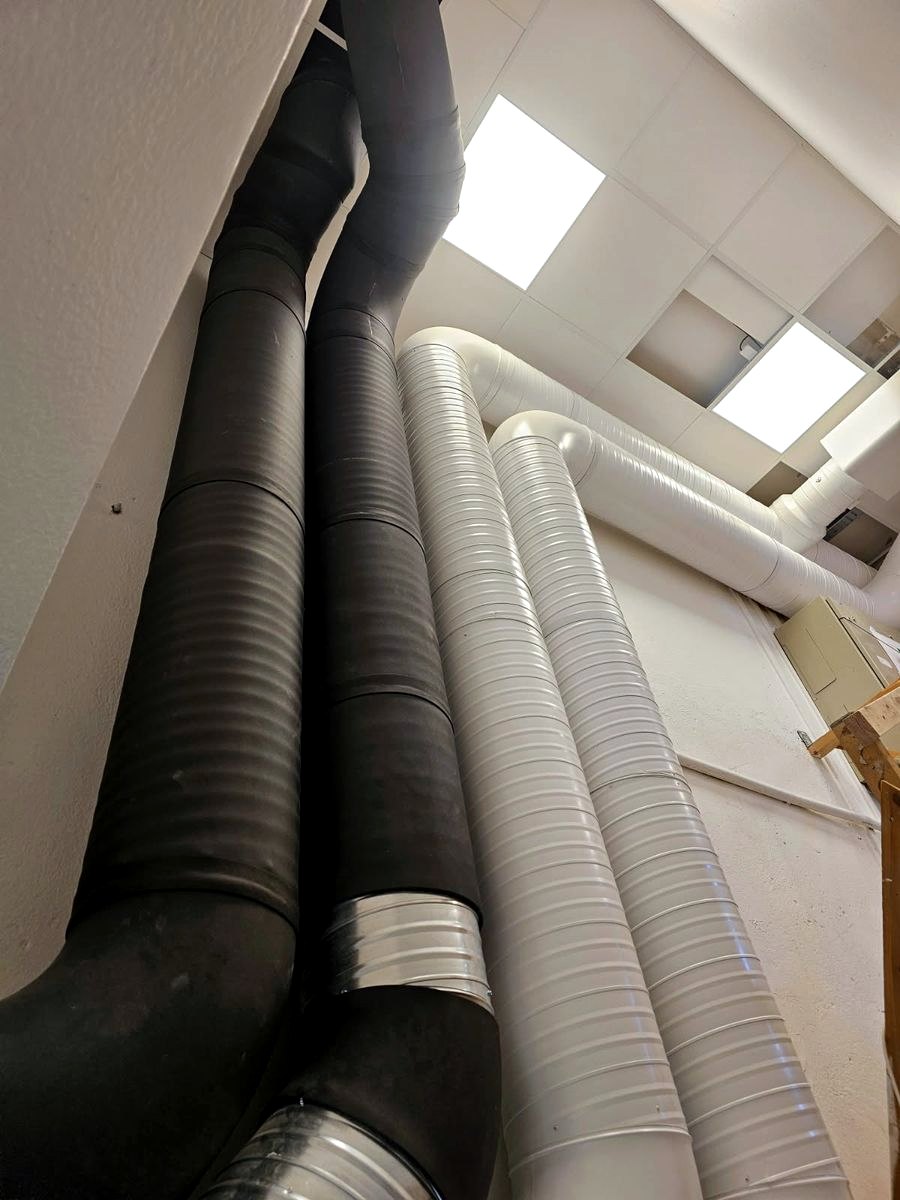 Isolerade och galvaniserade ventilationskanaler dragna vertikalt mellan våningsplan