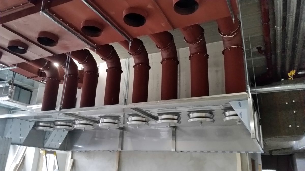 Installation av terrakottafärgade ventilationskanaler i tak, kommersiell fastighet